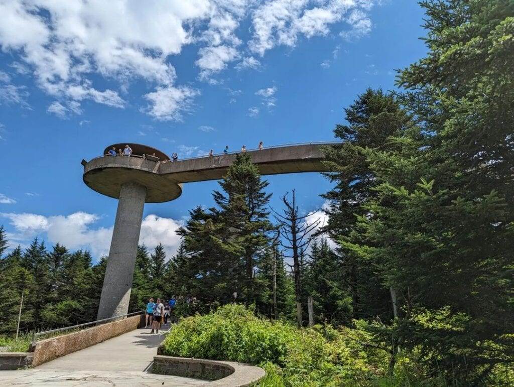 A hiker stands on Clingmans Dome in Great Smoky Mountains National Park under a clear autumn sky