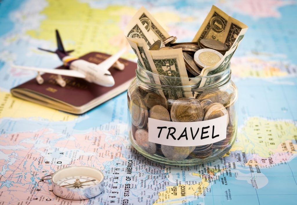 Traveler using maps and budget apps to plan affordable trips worldwide