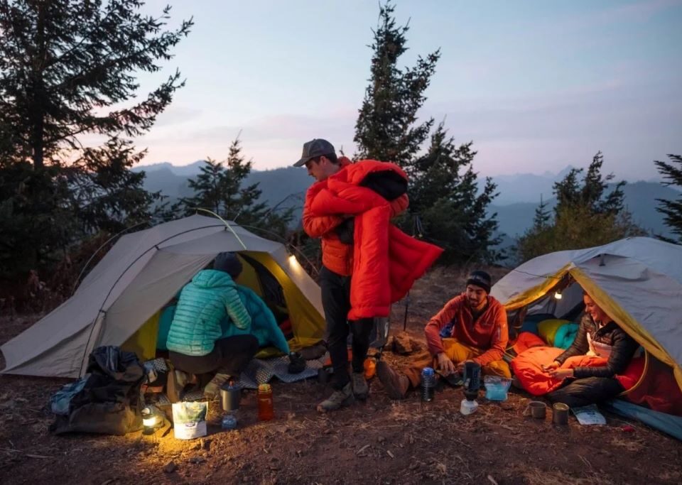 Campers in Colorado planning a safe wild camping trip with tent, map, backpack, and mountain trail setup.